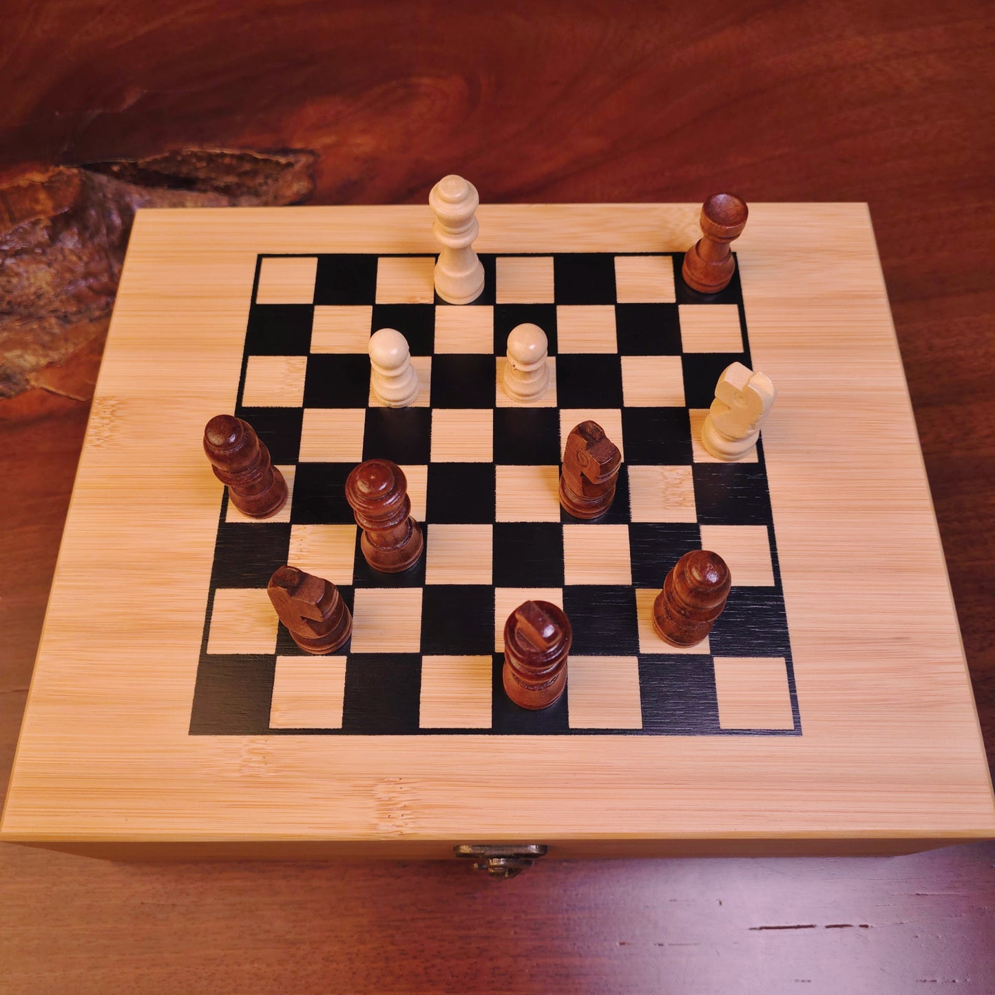 Wooden chessboard with pieces on a wooden surface