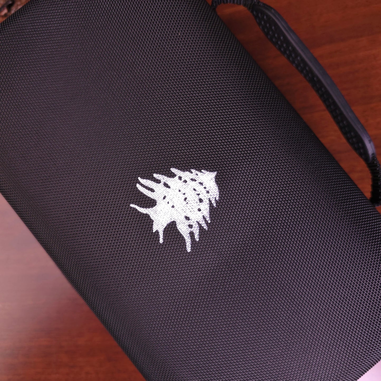 Black bag with a white logo on a wooden surface