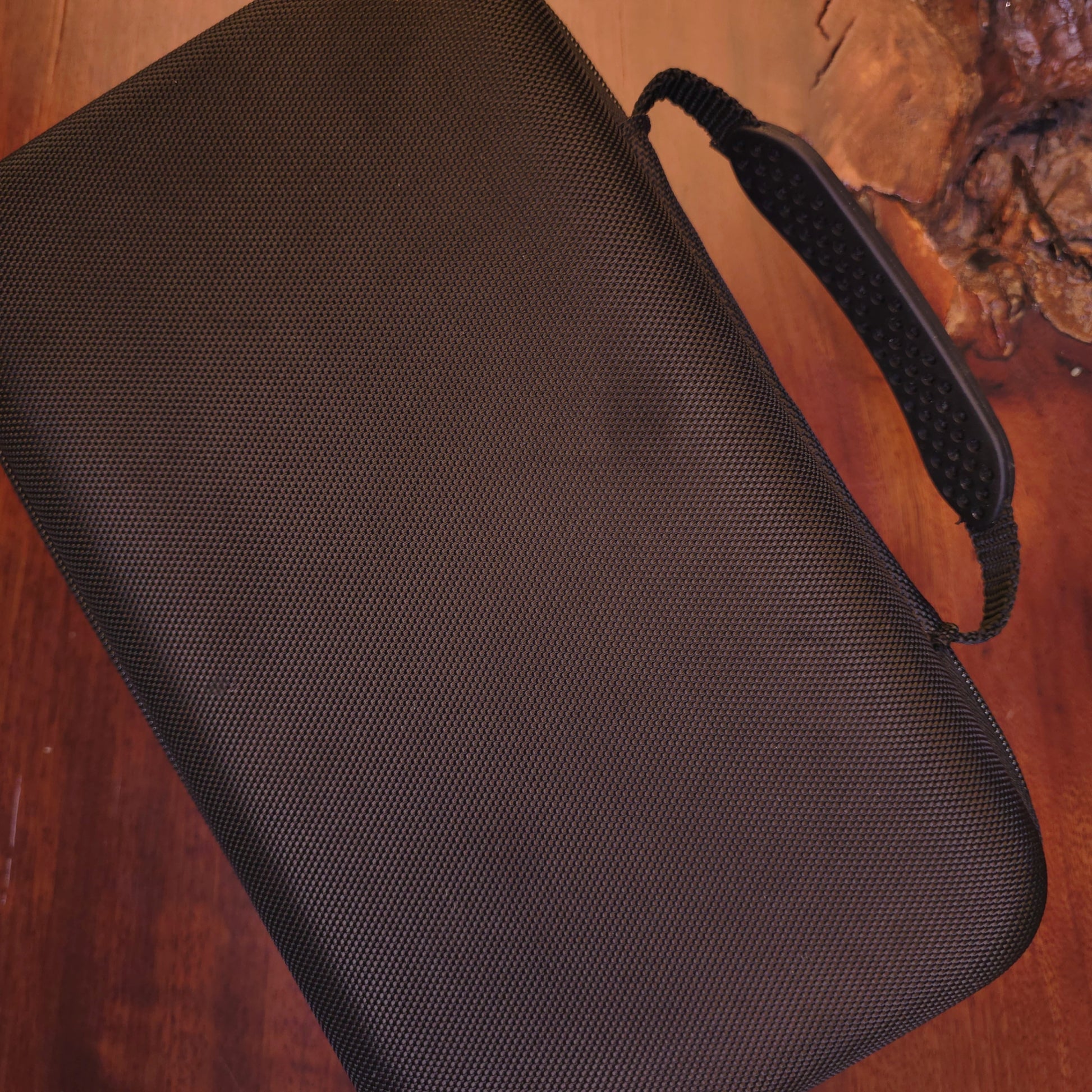Black textured pouch on a wooden surface