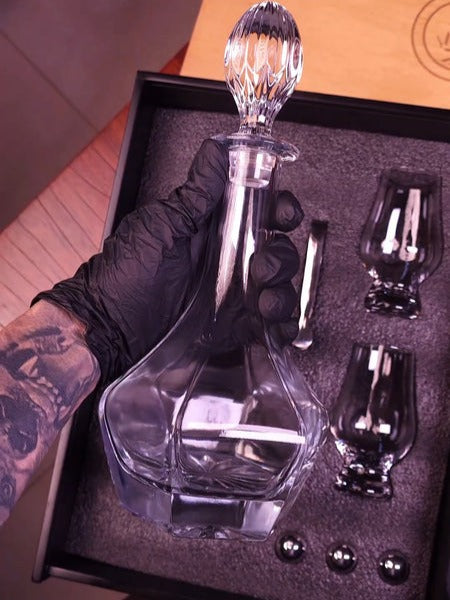 decanter glass with two glasses in the background 