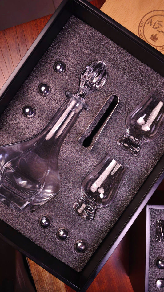 Set of Glencairn including a decanter, glasses, stainless steel stones, and tong in a black wooden box.