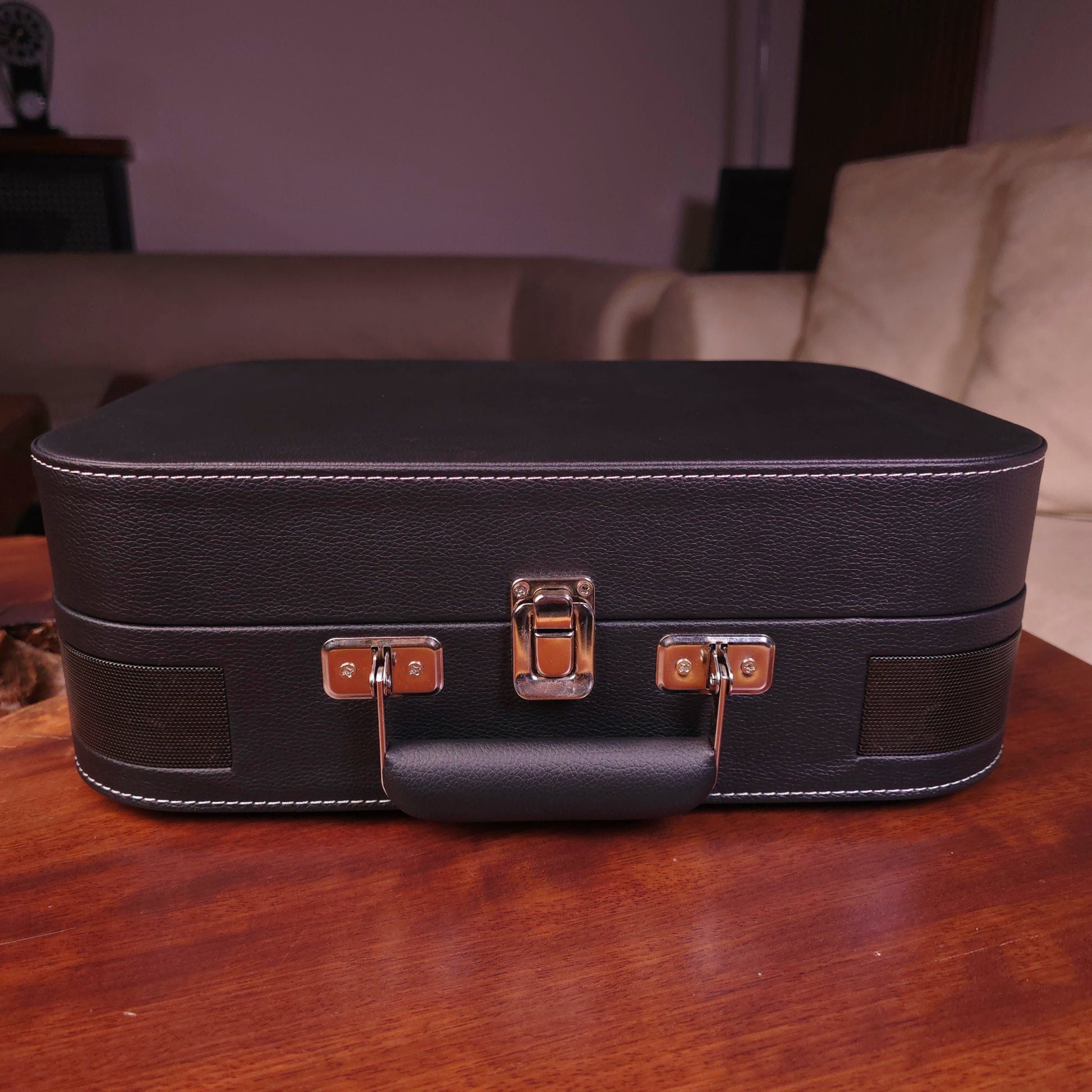 Black turntable mzaj case on a wooden table with a blurred background