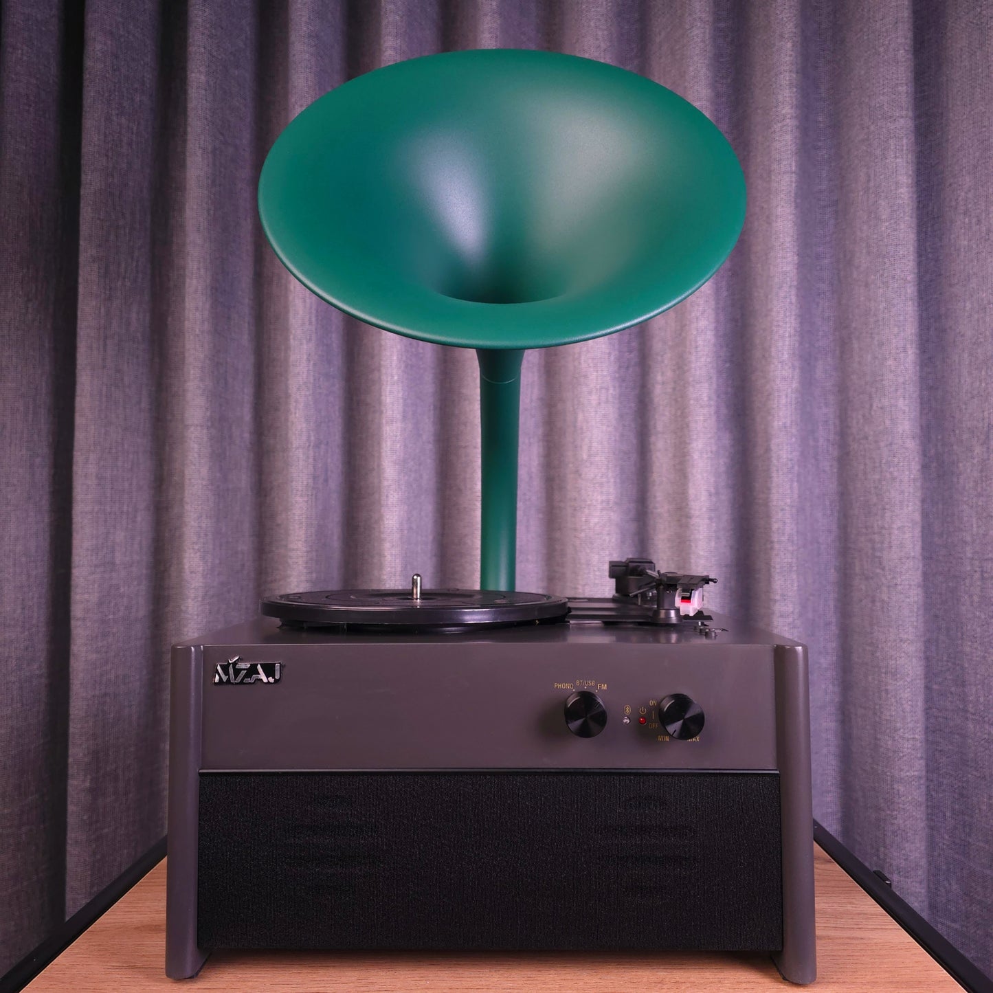 Vintage-style record player with a green horn against a gray curtain background