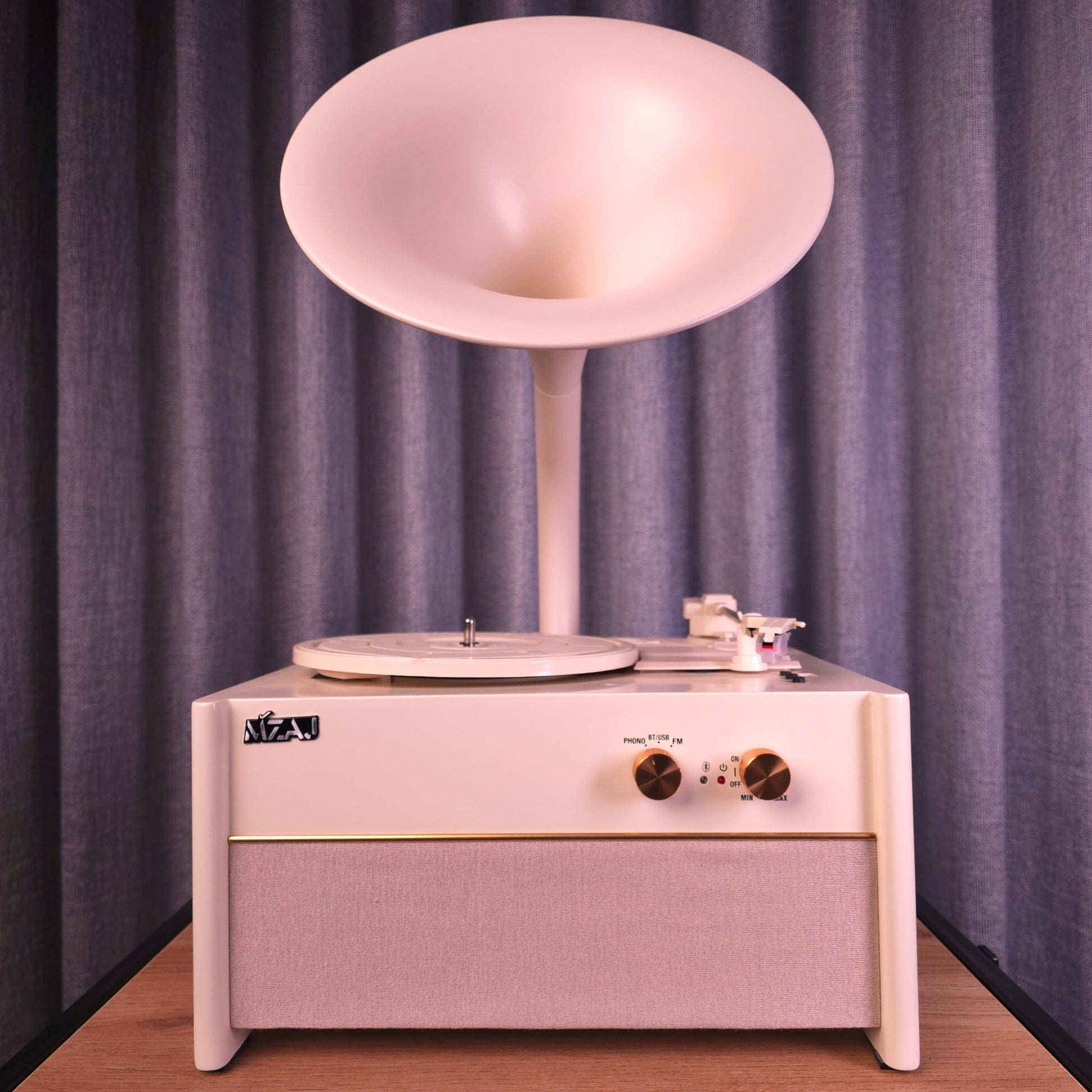 Vintage-style record player with a horn on top against a purple curtain background