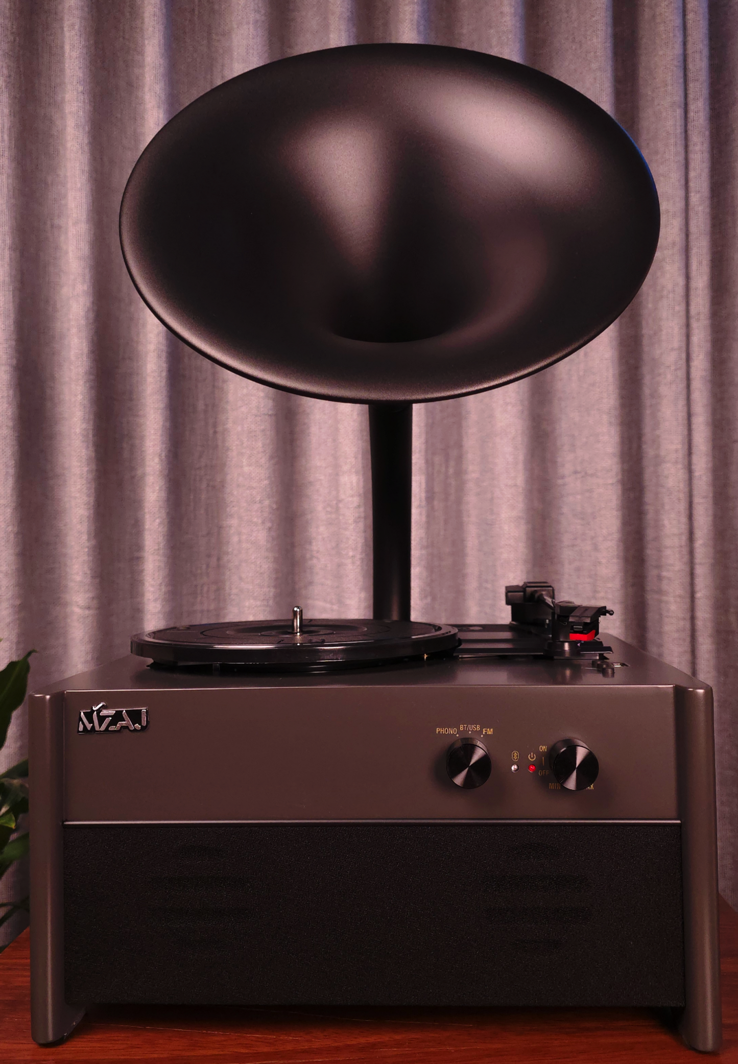 Vintage-style record player with a large black speaker against a curtain background